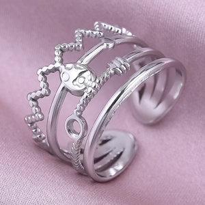 Macro detail of silver multi-layer adjustable ring featuring crown and braided textures