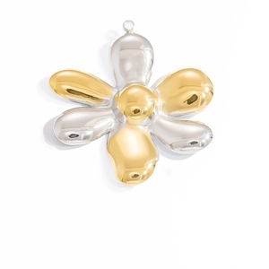 Macro view of a two-tone 18K gold and silver six-petal floral metal pendant charm