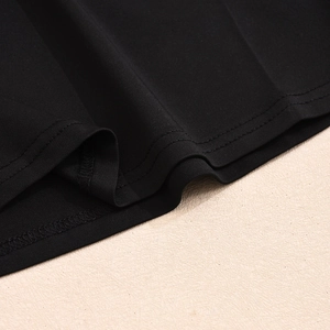 Detalle de costura de doble aguja y tejido de punto denso en el dobladillo de un top negro