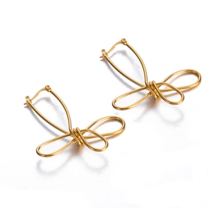 Detail of creative gold wire-wrapped bow earrings with a minimalist irregular design