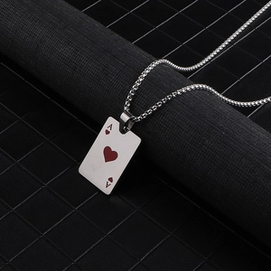 Macro detail of silver stainless steel Ace of Hearts playing card pendant on black background