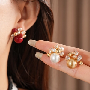 Detailed view of flower earrings with gold plating, zircons, and pearls on model