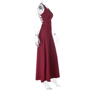 Detail of burgundy backless halter dress showing elegant crisscross straps and flowing hemline