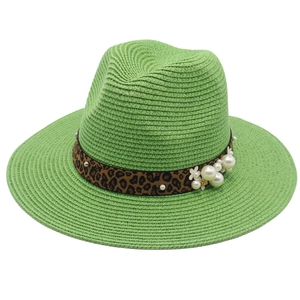 Detailed shot of green straw fedora hat featuring leopard print band and pearl flower accents