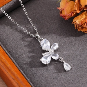 Detail of silver bow pendant necklace with sparkling zircons in a wooden jewelry box