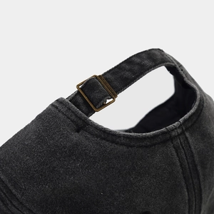 Detailed close-up of the vintage adjustable bronze buckle on this dark denim baseball cap