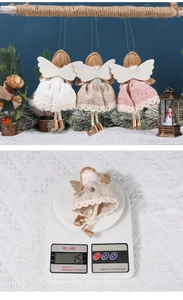 Vue détaillée de trois anges suspendus faits main en tons blanc, beige et rose tendre
