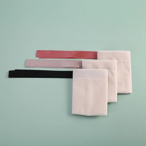 Detailed view of beige microfiber jewelry pouches with red, purple, and black ribbons