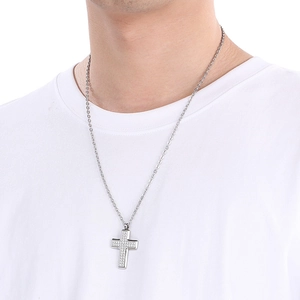 Detailed close-up of a silver cross pendant with CZ stones on a stainless steel chain
