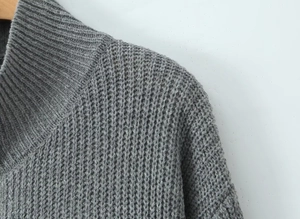Close-up of grey long cardigan showing thick knit texture and shoulder stitching detail