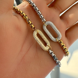Detailed macro of two-tone chain necklaces with oval pendants and micro-pave crystals