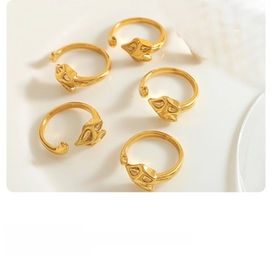 Detailed view of five-piece gold fox head open rings displayed on a white ceramic plate