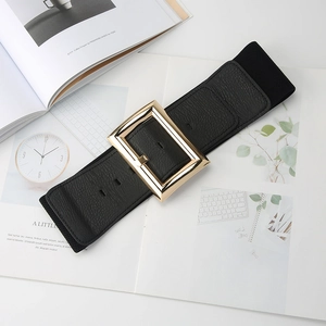 Macro shot of wide black elastic waist belt with large square gold buckle on magazine