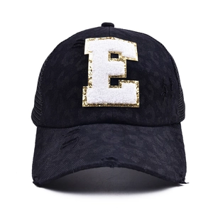 Close-up of black distressed mesh baseball cap with sequined letter E towel embroidery