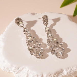 Detail of elegant silver geometric teardrop tassel earrings with sparkling rhinestones
