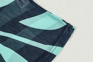 Close-up of tropical leaf print on semi-transparent mesh fabric with precise stitching detail