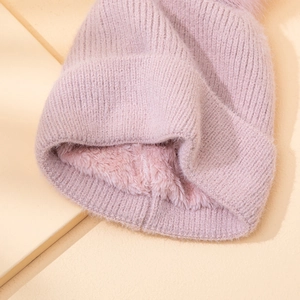Vista dettagliata di un berretto invernale in maglia rosa con calda fodera in peluche