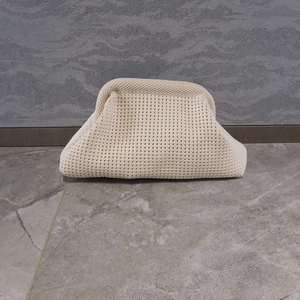 Detail shot showing the woven texture and pleated design of the beige knitted clutch bag
