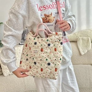 Quilted canvas tote featuring Christmas cartoon patterns and pink woven straps