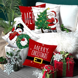 Set of four Christmas throw pillow covers with Santa and Snowman prints on a white sofa