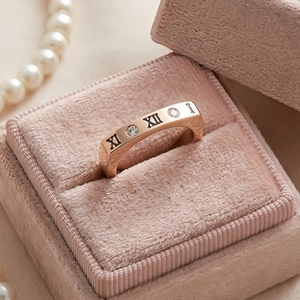 Vista macro dell'anello in acciaio oro rosa con numeri romani in scatola di velluto