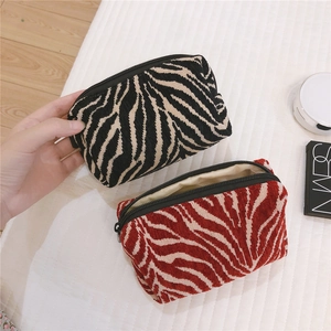 Detailed view of jacquard zebra print cosmetic bags with soft texture and metal zippers