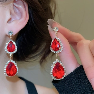 Detail of red teardrop earrings with gold plating and sparkling crystal accents
