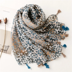 Close-up of lightweight gradient geometric scarf with fringe tassels and soft print