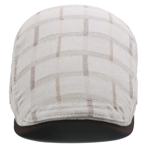 Detailed view of plaid cotton flat cap with beige grid pattern and brown visor contrast