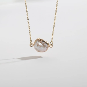 Macro view of baroque freshwater pearl pendant on a 14K gold plated chain necklace