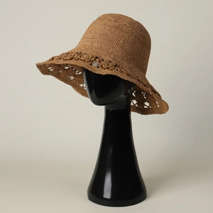 Detail of handmade raffia sun hat featuring exquisite hollowed-out flower weaving patterns