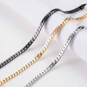 Close-up of flat cuban link chains in black, gold, and silver stainless steel finish