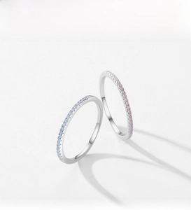 Detailed view of two slim S925 silver rings with light blue and purple crystals
