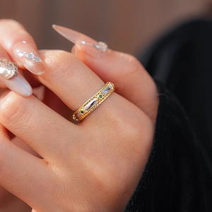 Close-up of vintage oval ring with green gemstones and braided gold-silver band detail