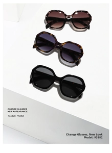 Three pairs of oversized geometric sunglasses in tortoiseshell, purple, and black on a white stand