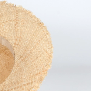 Handmade raffia sun hat with elegant fringed edges and lace bow for beach summer vacations