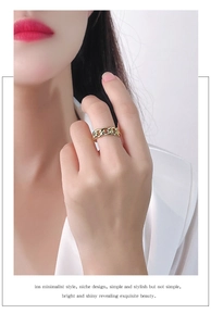 Detail shot of a layered 925 sterling silver chain ring in gold worn on a finger