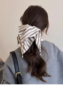 Détail d'un chouchou à rayures avec perles sur un modèle à coiffure élégante
