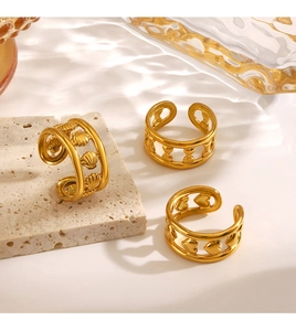 Detailed macro view of three gold-plated adjustable rings with shell and heart patterns