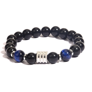 Polished tiger eye and black obsidian bead bracelet with sparkling silver accents on white background