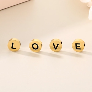 Polished gold stainless steel round alphabet beads spelling LOVE for DIY jewelry