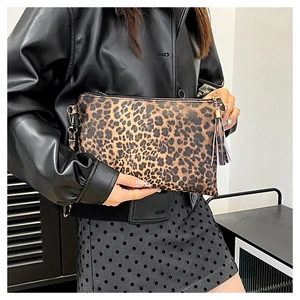 Detailed view of the leopard print clutch bag with decorative tassels on the side