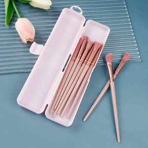 Detail of pink makeup brush set with 8 brushes in a transparent storage box container