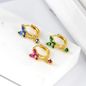 Detail of butterfly hoop earrings with blue, green, and pink crystals on marble