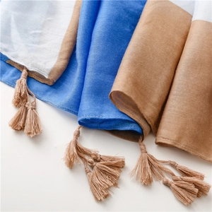 Detailed close-up of color-block scarf with blue, brown, and white panels and fringe