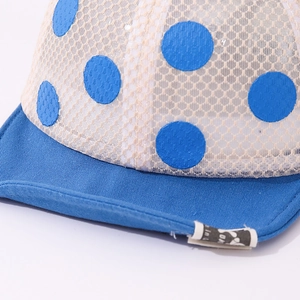 Détail du tissu en maille respirant et des pois bleus sur la casquette pour enfants