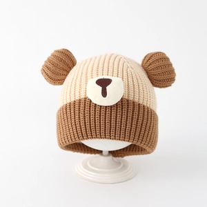 Détails d'un bonnet bébé ours avec coutures contrastées et maille côtelée douce