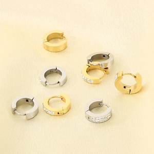 Detail view of gold and silver stainless steel hinged earrings with white zircons