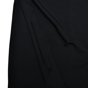 Détail du tissu noir de la robe de soirée montrant les plis doux et la texture lisse