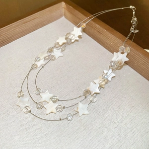 Détail du collier argenté à trois rangs avec étoiles en nacre et perles de cristal